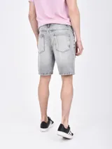 Bermuda de jean azul con roturas y desgaste.