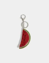 Llavero con dije de sandía decorado con strass rojos, verdes y negros, y mosquetón metálico plateado.