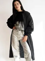 Campera bomber larga color negro, con cierre frontal y bolsillos laterales.