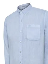 Camisa de lino color verde oliva, con cuello camisero, teñida en prenda. Tiene un bolsillo en el pecho con bordado al tono. De manga larga y calce regular.