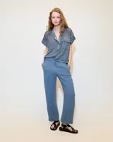 Remera celeste de lino y ramio, con corte boxy, manga japonesa, cuello mao, media cartera con broches metálicos y bolsillo plaqué con efecto de tapa.