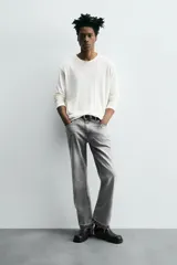 Pantalón de jean celeste de corte flare, con cinco bolsillos, efecto lavado y bajo con acabado irregular.