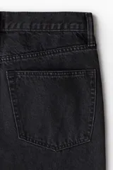 Pantalón de jean negro de corte recto y holgado, con tiro alto y cinco bolsillos.