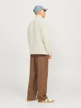 Buzo de fleece color beige con cuello alto y cierre de cremallera, mangas largas y puños de canalé.