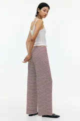 Pantalón de pierna amplia en punto suave a rayas horizontales color borgoña y blanco. Modelo con elástico revestido y cordón para ajustar en la cintura.