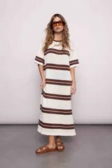 Vestido largo tejido a rayas horizontales marrones y crudas, con tajos a los costados y mangas cortas. Diseño oversize.