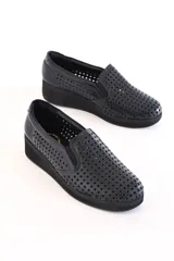 Panchitas Aura de cuero negro calado, con plataforma baja y elásticos laterales.