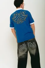 Pantalón jean negro de corte baggy con lavado localizado y aplique bordado en la parte trasera.