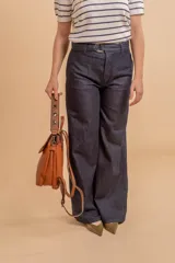 Mochila color verde oliva, tipo cartera, con tapa y doble cierre. Tiene dos compartimentos y división interna, además de un bolsillo trasero con cierre.