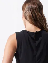 Blusa sin mangas color amarillo, con cuello redondo con frunces delanteros y abertura con botón en la espalda.