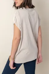 Blusa italiana color celeste con bordado de plumas al tono en el frente, confeccionada en lino y algodón.