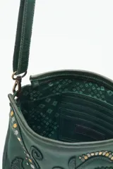 Cartera bandolera verde de cuero vacuno con bordado de flores y tachas doradas y plateadas. Tiene cierre metálico superior, forro de algodón, división interna, bolsillo y tarjetero. La correa es regulable.