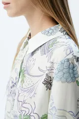 Camisa de tencel color crudo con estampado orgánico en tonos verdes y lilas. Presenta un calce recto, mangas largas y cierre frontal con botones.