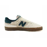 Championes New Balance color beige con detalles en verde y suela marrón. Presenta el logo de la marca en el lateral.