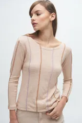 Remera gris de corte ajustado, con cuello redondo y mangas largas. Presenta líneas verticales bordadas en color verde claro y blanco.