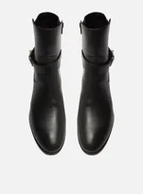 Bota corta de cuero color marrón con hebilla dorada y taco bajo.