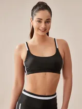 Top deportivo negro con tirantes finos blancos y banda inferior blanca.