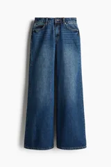 Pantalón de jean azul de corte acampanado, con tiro medio y cinco bolsillos.