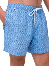 Short de baño celeste con estampado de ballenas en azul y gris. Tiene cintura elástica con cordón ajustable y bolsillos laterales.