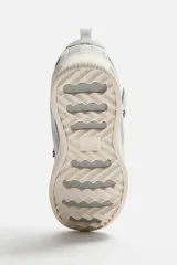 Zapatilla deportiva color beige, estilo skate. Capellada fabricada en combinación de piezas y materiales. Lengüeta acolchada. Detalle de cordones de cuerda. Tirador trasero para facilitar el calce. Suela con volumen y diseño irregular.