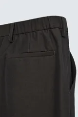 Pantalón de vestir negro de corte recto, con cintura elástica, pliegues frontales, bolsillos laterales y traseros.