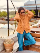 Cárdigan tejido color tostado, de lana, con cuello redondo y abotonadura frontal.