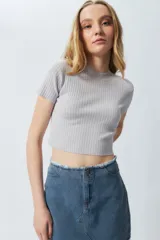Top gris de tejido de punto acanalado, elastizado, de manga corta y cuello alto.
