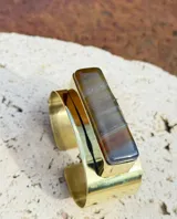 Pulsera rígida de alpaca plateada con piedra rectangular color celeste con vetas horizontales.