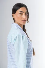 Pijama de algodón a rayas verticales celestes y blancas, compuesto por una camisa de manga larga con botones y un short con elástico en la cintura.