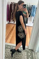 Vestido largo negro con bordado de flores doradas en el lateral y tajo en la pierna.