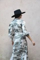 Vestido largo camisero de seda con estampado de tigres y árboles, cuello solapa con botones, faja para anudar, falda amplia y mangas abuchonadas con puño.