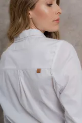 Camisa blanca de algodón con cuello tipo masculino, abotonadura central, manga larga y puños con botones. Canesú y cuello bordado con cadeneta a contratono.