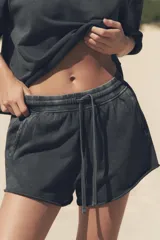 Shorts de tiro alto confeccionados en tejido con efecto lavado, cintura elástica ajustable con cordones, bolsillos laterales de vivo y tejido combinado en rib a tono.