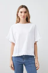 Blusa blanca con volados en mangas y ruedo.