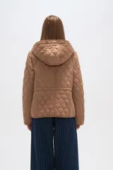 Campera blanca con diseño acolchado, cierre frontal con botones a presión y capucha desmontable.