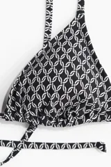 Top de bikini triangular con estampado geométrico en blanco y negro. Tiene tirantes finos ajustables y copas con relleno extraíble.