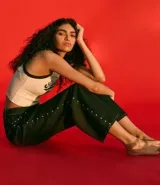 Pantalón loose de cintura baja confeccionado en jeans azul oscuro, con trabillas en la cintura, cierre tradicional, bolsillos y tachas aplicadas desde los bolsillos delanteros hasta los laterales.