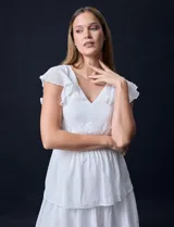 Vestido blanco de gasa con capas de la marca Julia Jordan. Tiene escote en V, mangas cortas con volados, corte en la cintura, abertura central en la espalda con cierre invisible y forro interno a tono.