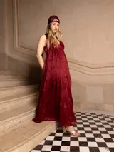 Vestido largo negro con escote en V, breteles finos con lazo y bordados florales a tono. Corte imperio y falda amplia con volados. 