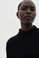 Top entallado negro de microfibra suave con cuello alto y manga francesa.