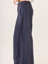 Pantalón de pierna ancha color azul marino con pespuntes a contratono (rojo/bordó) y una tira contrastante en el lateral.