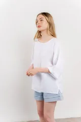 Blusa color beige confeccionada en lino, de corte holgado, mangas 3/4 y cuello redondo.