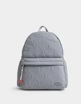 Mochila gris acolchada de tela deportiva con bolsillo frontal con cierre y tirador de goma. Tiene correas regulables, manija superior, cierre superior, bolsillos laterales y etiqueta metálica.