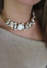 Gargantilla rígida dorada con doble aro y apliques de perlas irregulares y piezas de nácar.