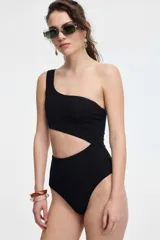 Malla enteriza negra con textura acanalada, corte asimétrico de un hombro y abertura en la cintura.