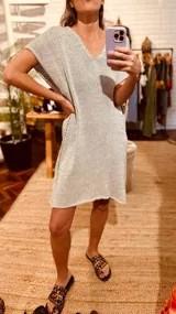 Vestido corto tejido en lurex metálico plateado, con escote en V y mangas cortas.