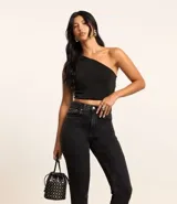 Blusa cropped negra de poliéster y elastano, con un solo hombro descubierto, fruncido lateral y bretel torcido.