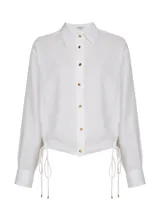 Camisa blanca de lino, de corte clásico, con cuello camisero y mangas largas con puños abotonados.