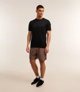Bermuda deportiva marrón confeccionada en tejido respirable de poliéster y elastano, con cintura elástica, cordón interno ajustable, bolsillos laterales y aberturas laterales.