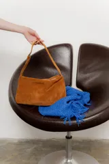Cartera de hombro de gamuza color tostado con correa corta.